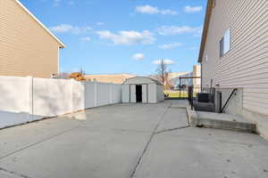 Fenced backyard with a storage shed and a patio area
