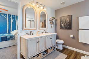 Bathroom with double vanity, ensuite bathroom, a shower with curtain, and a ceiling fan