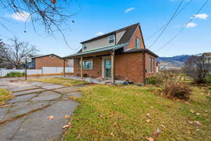 View of front of property featuring brick siding and covered porch