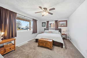 Bedroom featuring light colored carpet, ceiling fan, and a textured ceiling