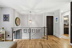 Hall featuring an upstairs landing, light wood finished floors, and recessed lighting