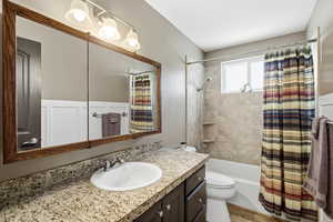 Full bath featuring vanity and shower / bathtub combination with curtain