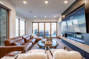 Living area with wood finished floors, a premium fireplace, and recessed lighting