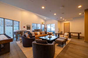 Living room with recessed lighting, hardwood / wood-style floors, and high vaulted ceiling