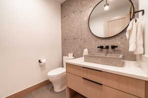 Half bath featuring vanity and tasteful backsplash