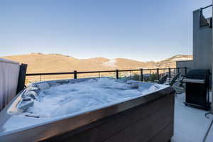 View of patio / terrace with a hot tub, area for grilling, and a mountain view