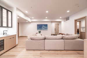 Living area featuring recessed lighting, light wood-type flooring, wine cooler, and wet bar