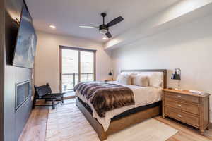Bedroom with access to outside, light wood-type flooring, ceiling fan, and recessed lighting