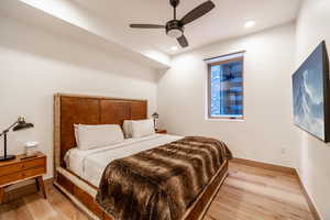 Bedroom with light wood-style floors, a ceiling fan, and recessed lighting