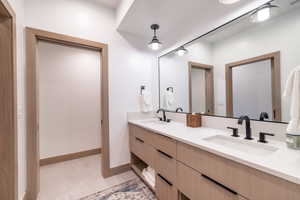 Bathroom with double vanity and baseboards