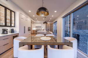 Dining space with recessed lighting, wine cooler, and light wood-style flooring