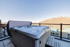 Balcony featuring a hot tub and a deck with mountain view