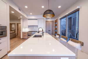 Kitchen with white cabinetry, recessed lighting, a spacious island, decorative light fixtures, and modern cabinets