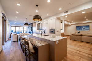 Kitchen with open floor plan, modern cabinets, a spacious island, light wood-style floors, and recessed lighting