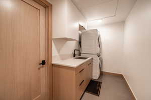 Washroom with stacked washer / dryer and cabinet space
