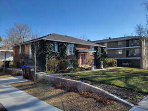 View of front of property featuring a front lawn and brick siding