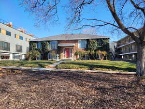 Raised ranch with brick siding and a front yard