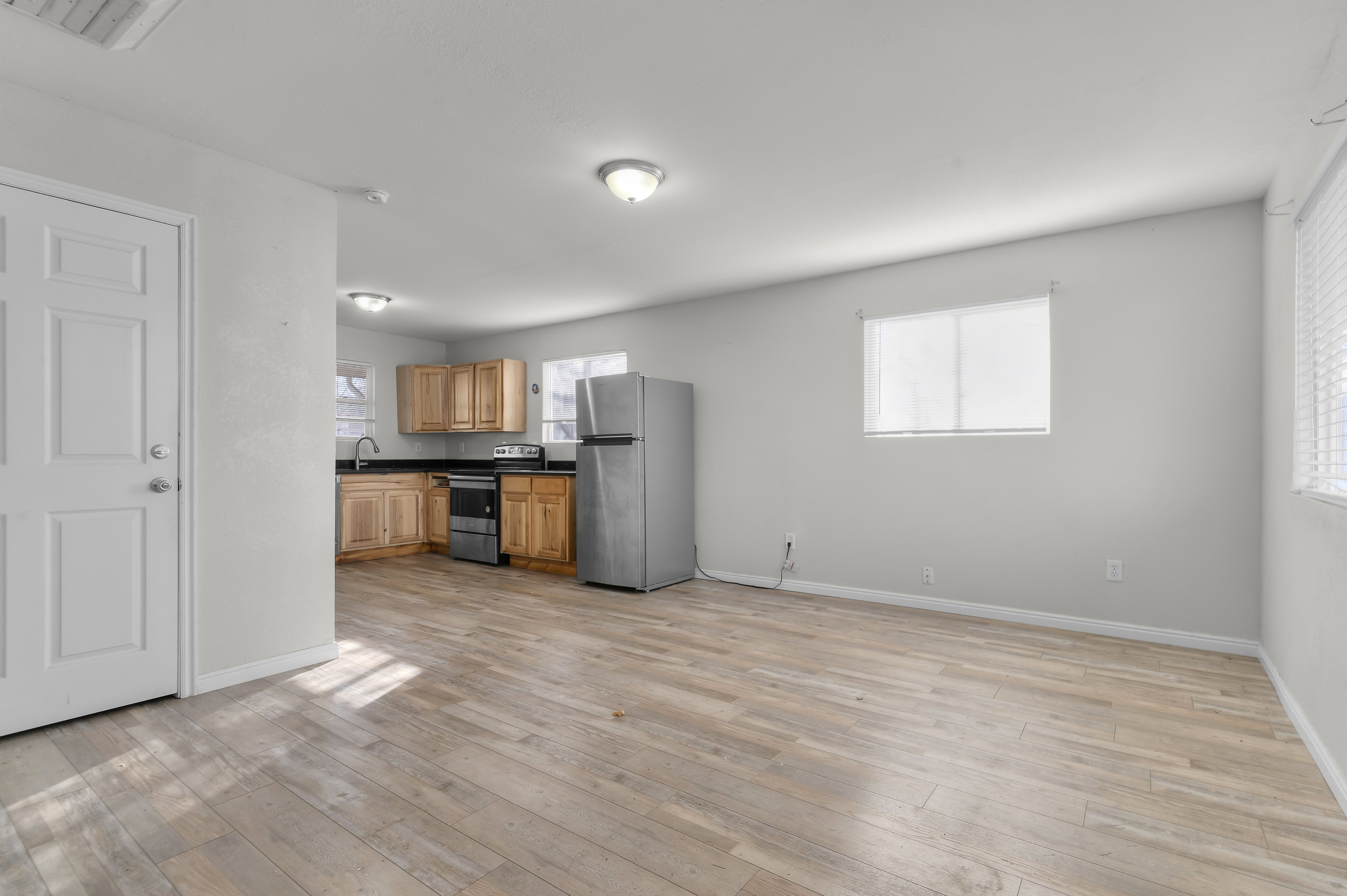 Kitchen featuring dark countertops, appliances with stainless steel finishes, and light wood-style flooring