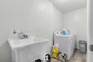 Washroom featuring light wood finished floors and washer and clothes dryer