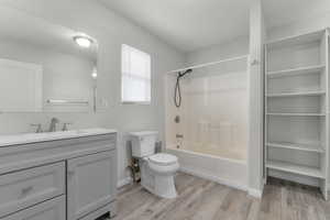 Bathroom with vanity, light wood-type flooring, and shower / washtub combination