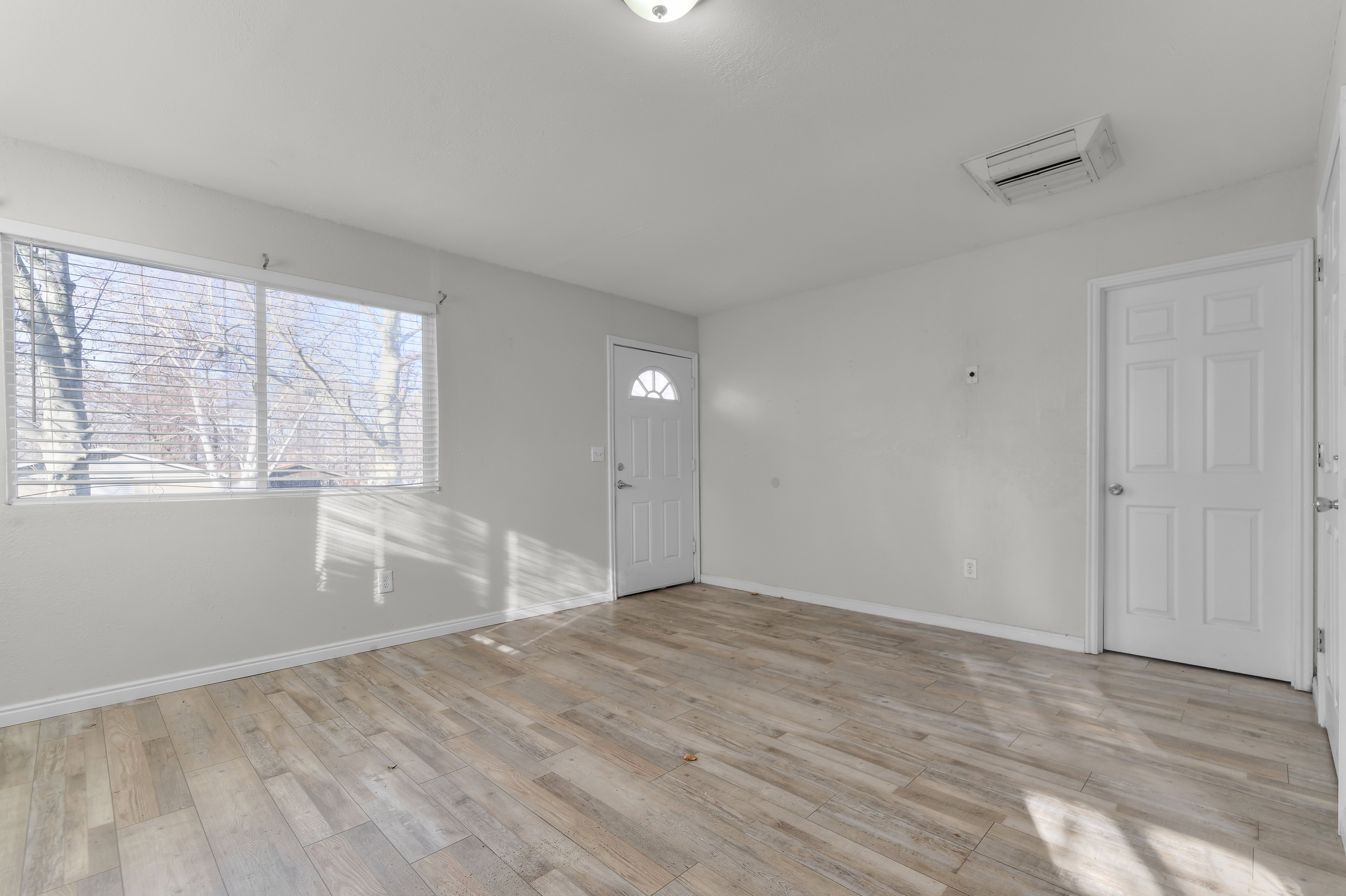 Foyer entrance with cooling unit and light wood-style floors
