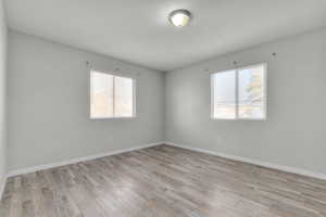 Unfurnished room featuring light wood-type flooring and plenty of natural light