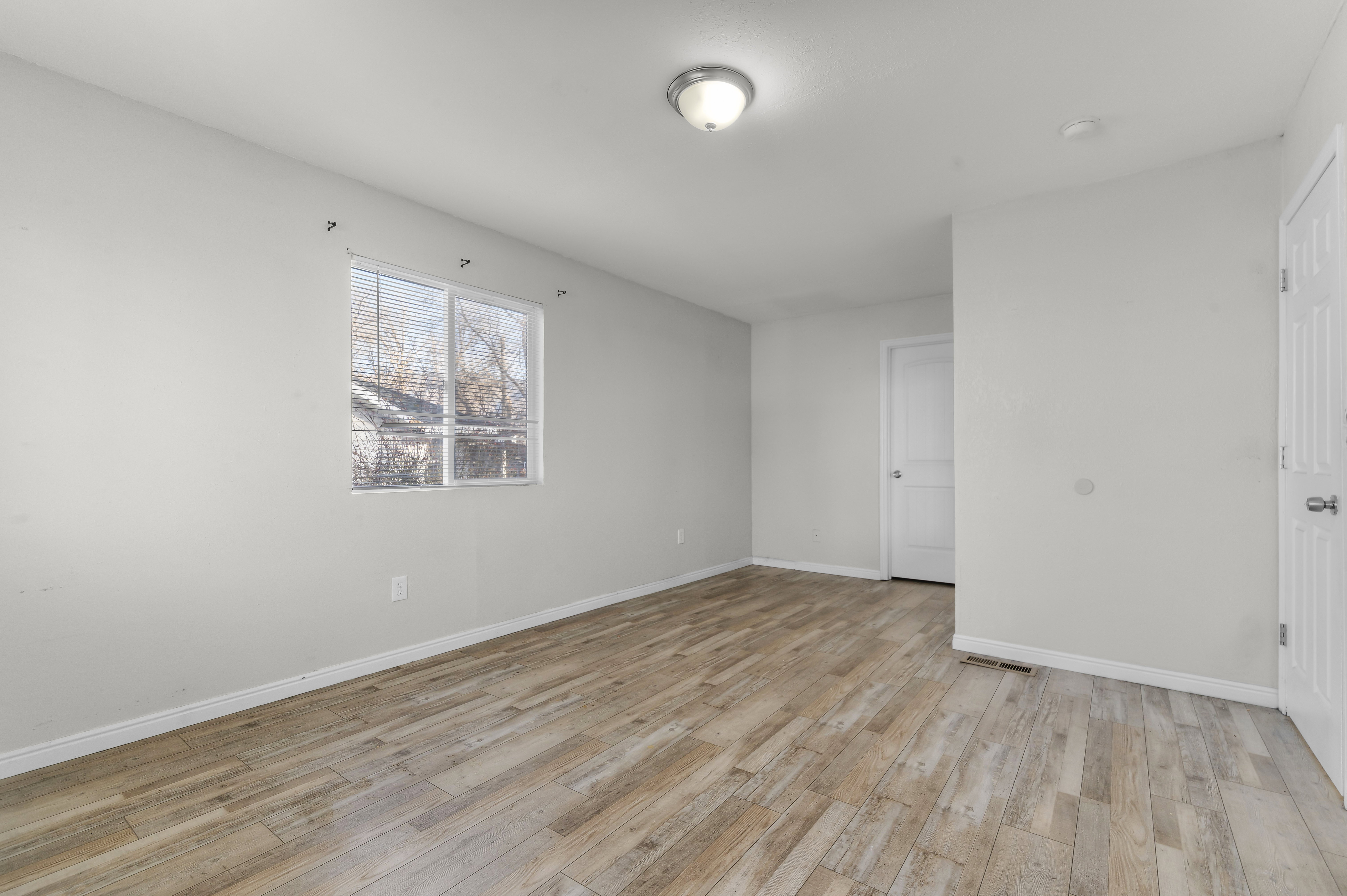 Unfurnished room with light wood-style floors and baseboards