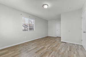 Unfurnished room with light wood-style floors and baseboards