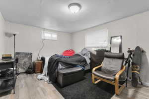 Bedroom with a textured ceiling and light wood-style flooring