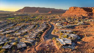Aerial view of property and surrounding area featuring mountains and nearby suburban area