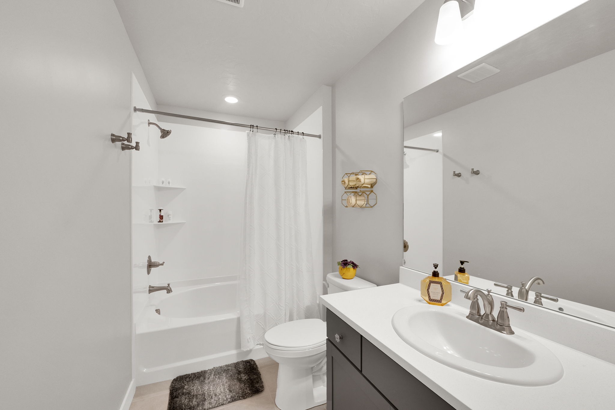 Full bath featuring shower / tub combo with curtain, vanity, and light tile patterned flooring