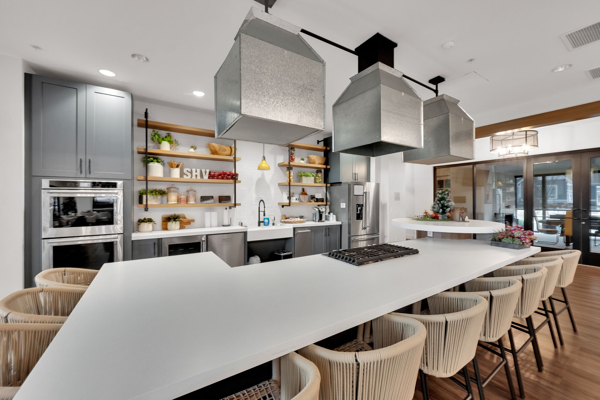 Kitchen featuring a kitchen breakfast bar, gray cabinetry, open shelves, stainless steel appliances, and recessed lighting