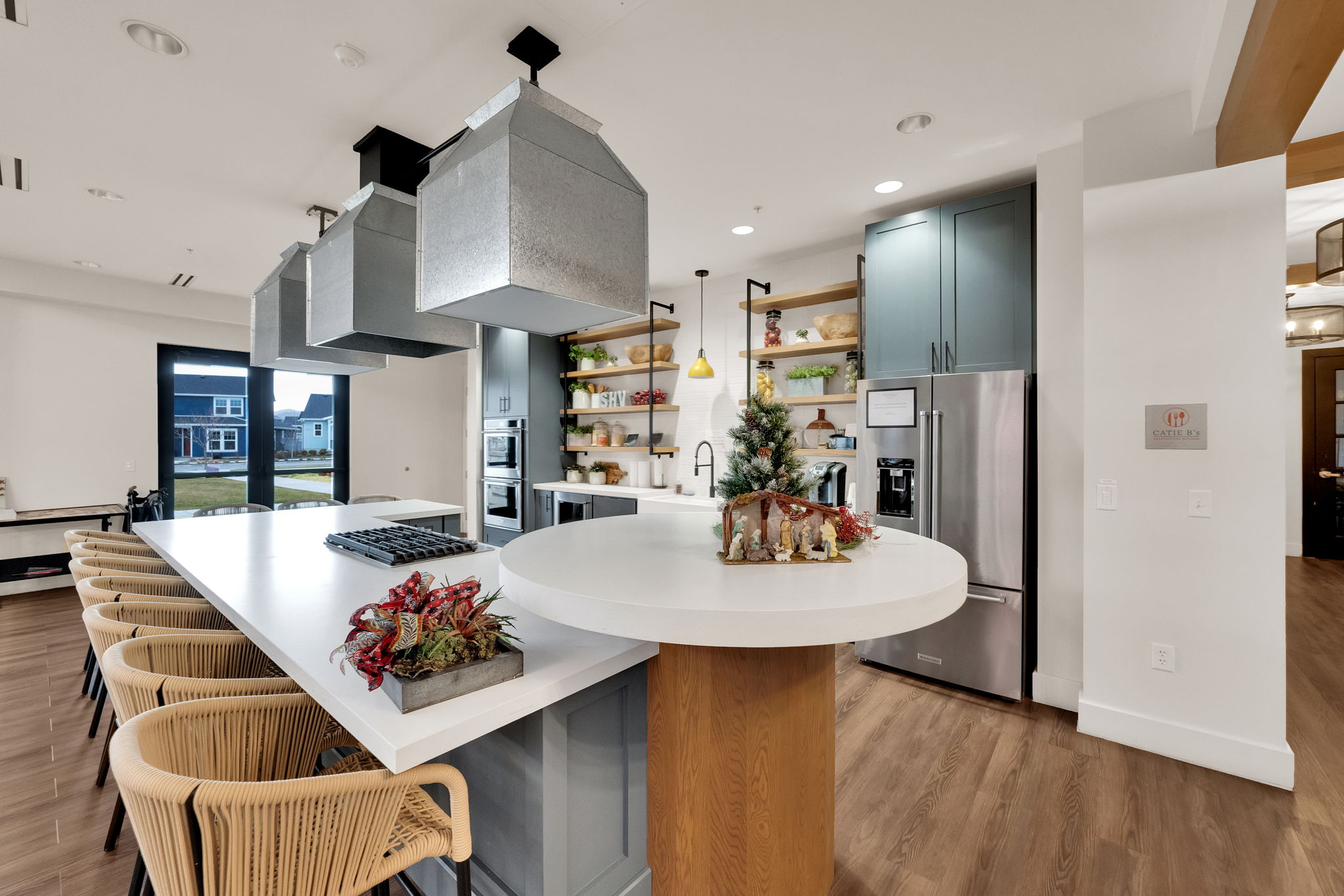 Kitchen featuring open shelves, stainless steel appliances, light wood-style flooring, a kitchen bar, and pendant lighting