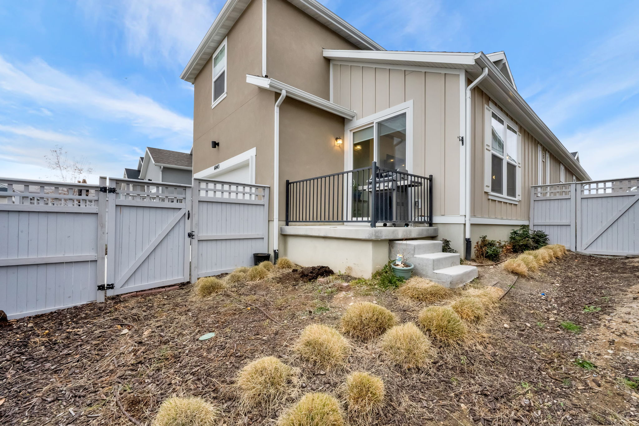 View of home's exterior featuring a gate, a deck, and board and batten siding
