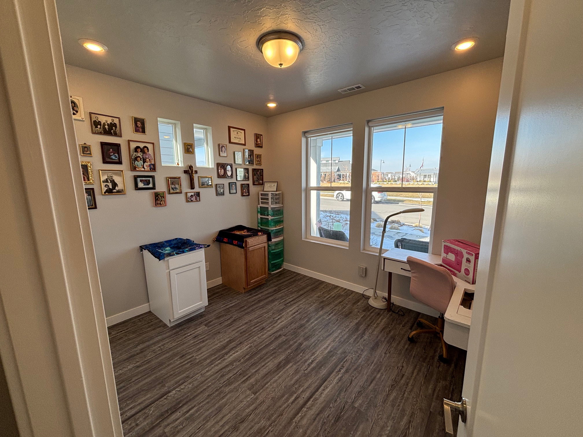 Home office with a textured ceiling, dark wood-type flooring, and recessed lighting