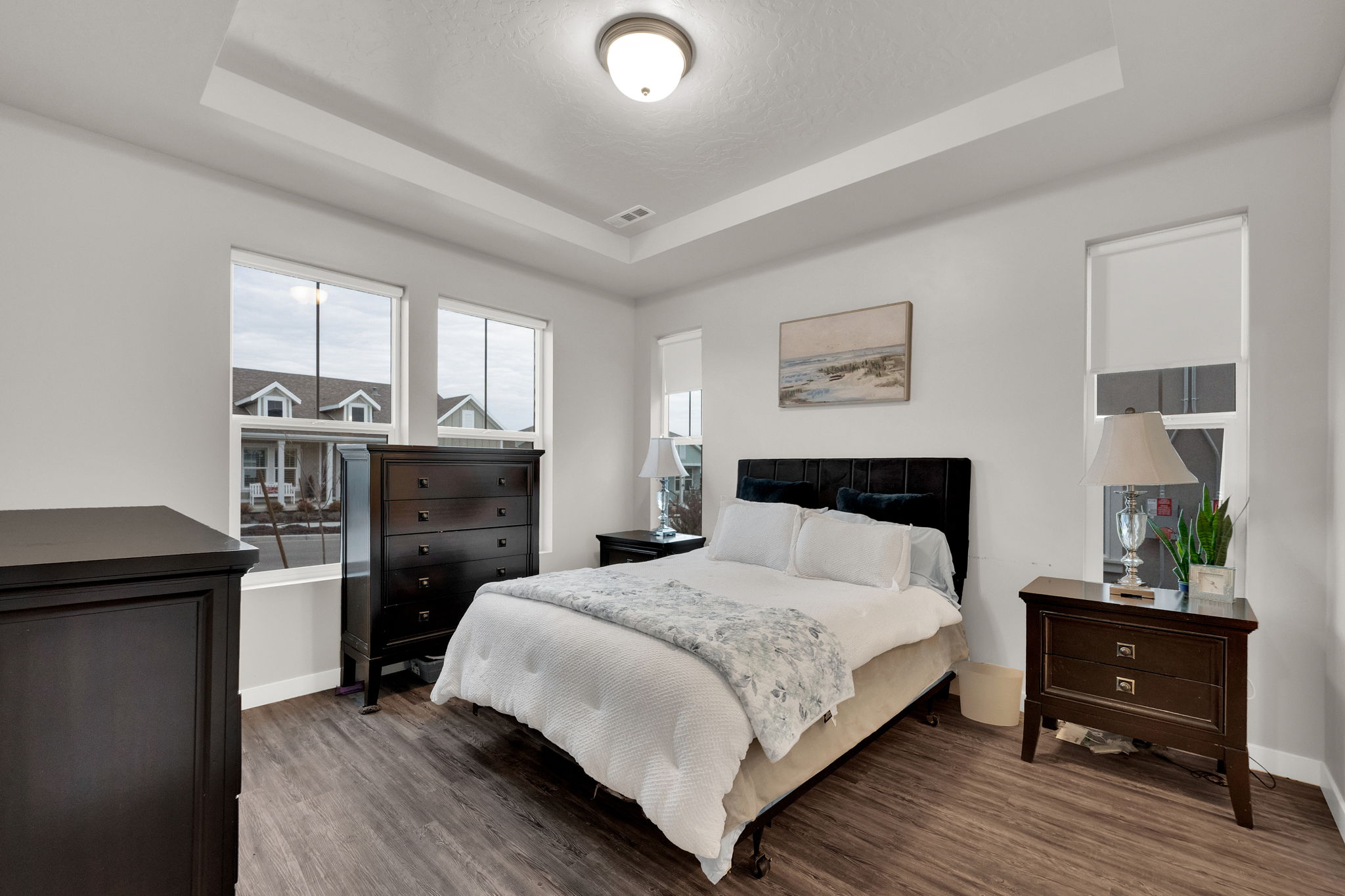 Bedroom featuring a raised ceiling and wood finished floors