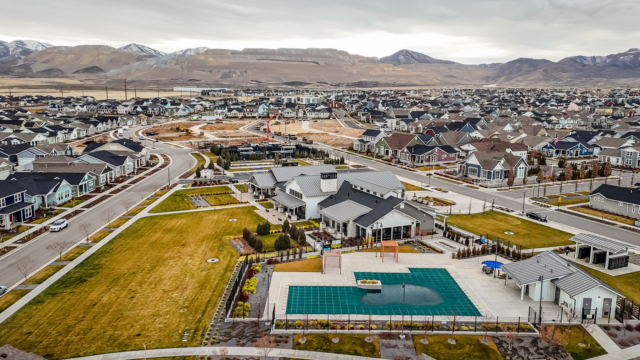 Aerial perspective of suburban area featuring a mountainous background and a pool area