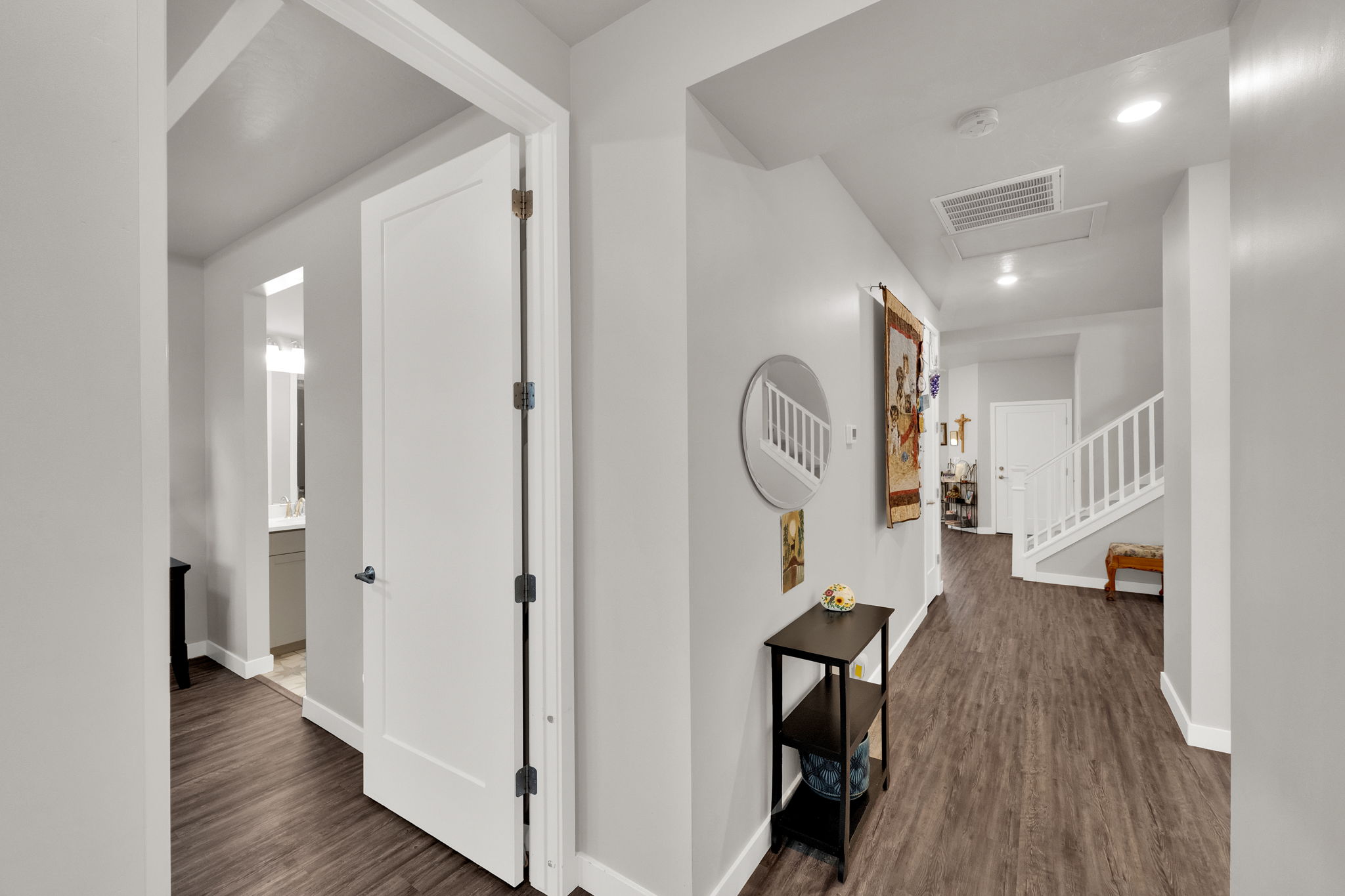 Hall featuring dark wood-type flooring, recessed lighting, and stairs