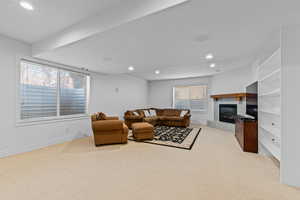 Living area featuring recessed lighting, a tile fireplace, light carpet, and plenty of natural light