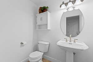Half bathroom featuring toilet and light tile patterned floors