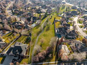 Aerial view of property and surrounding area featuring nearby suburban area