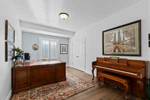 Home office with dark wood-style floors and baseboards