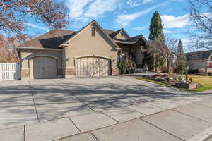 View of front facade featuring stucco siding, an attached garage, and driveway