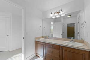 Bathroom with double vanity and light carpet