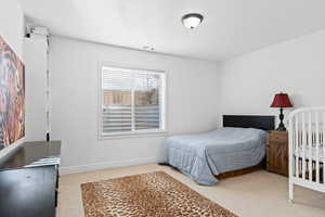Bedroom with light carpet and baseboards