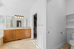 Bathroom featuring a walk in closet, double vanity, a shower stall, and a bath