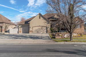 View of front facade with stucco siding, concrete driveway, and a garage