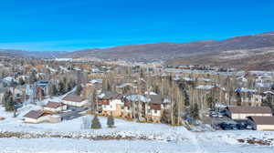 Snowy aerial view featuring a mountain view and a residential view