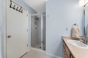 Bathroom with vanity, a stall shower, and light tile patterned flooring