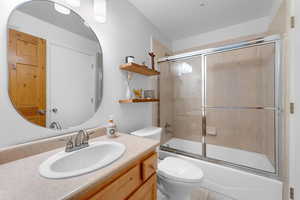 Bathroom featuring vanity and shower / bath combination with glass door
